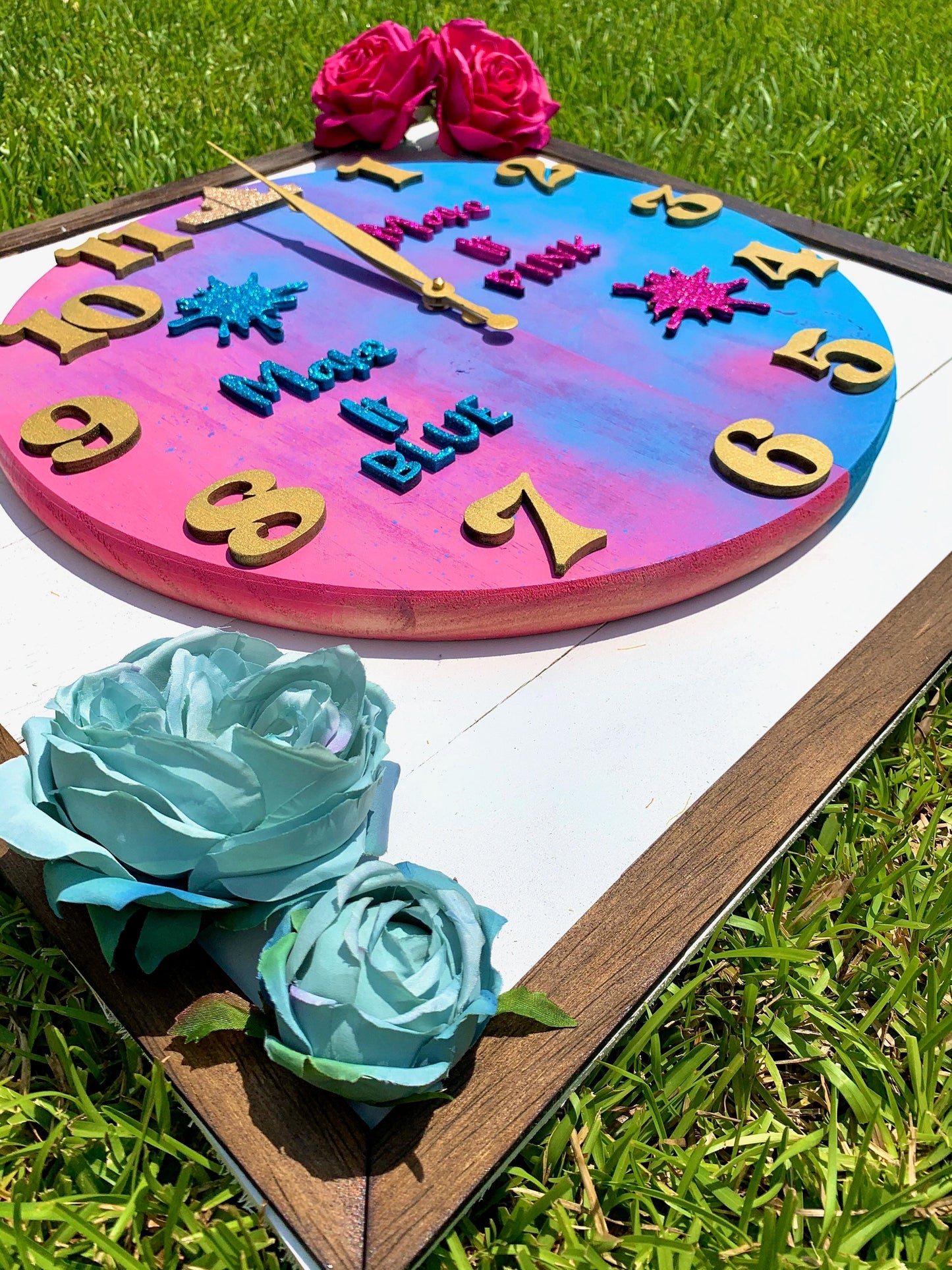 Colorful clock with decorative flowers on a grassy background