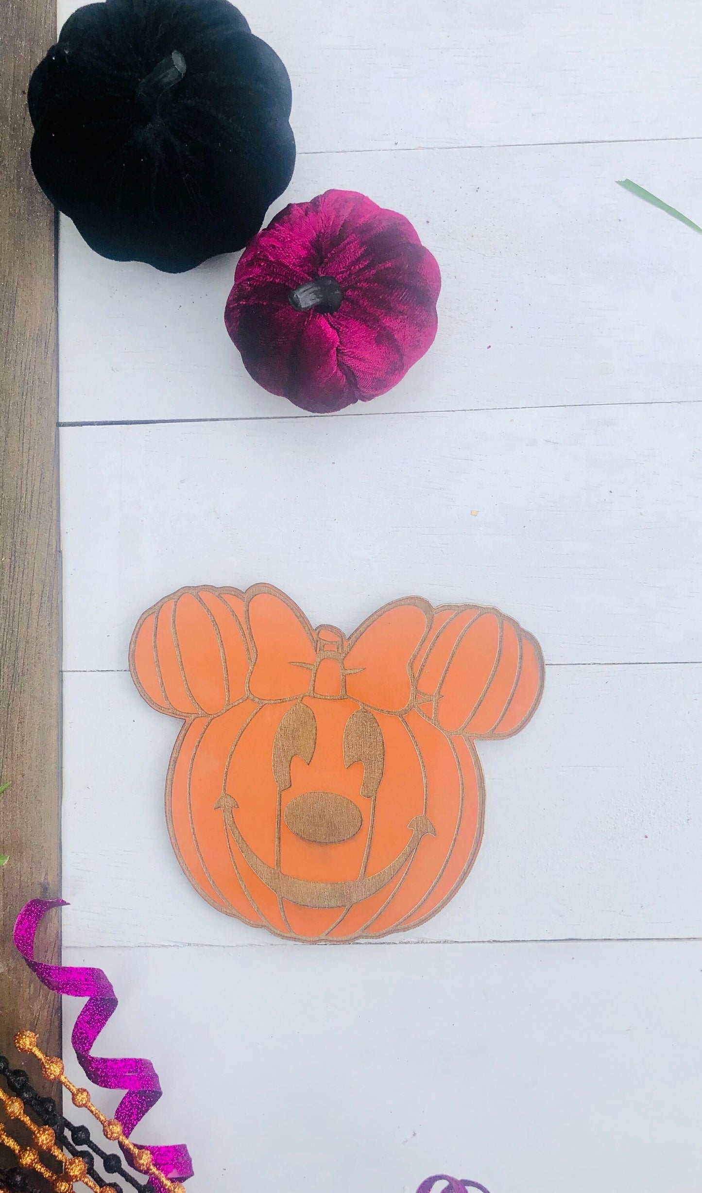 Decorative pumpkin with a smiley face design on a white floor.