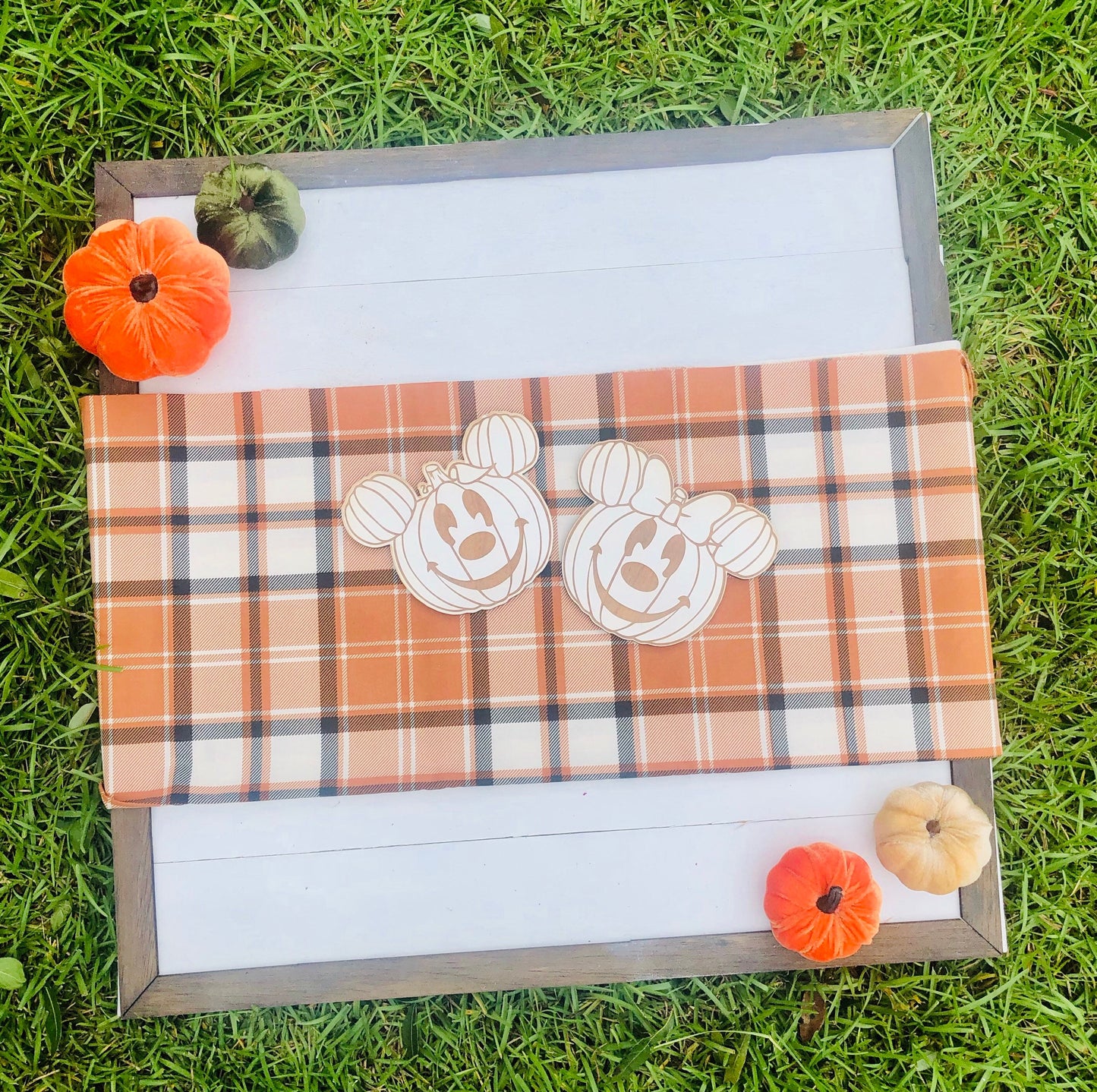 Plaid blanket with pumpkin designs on a grassy background