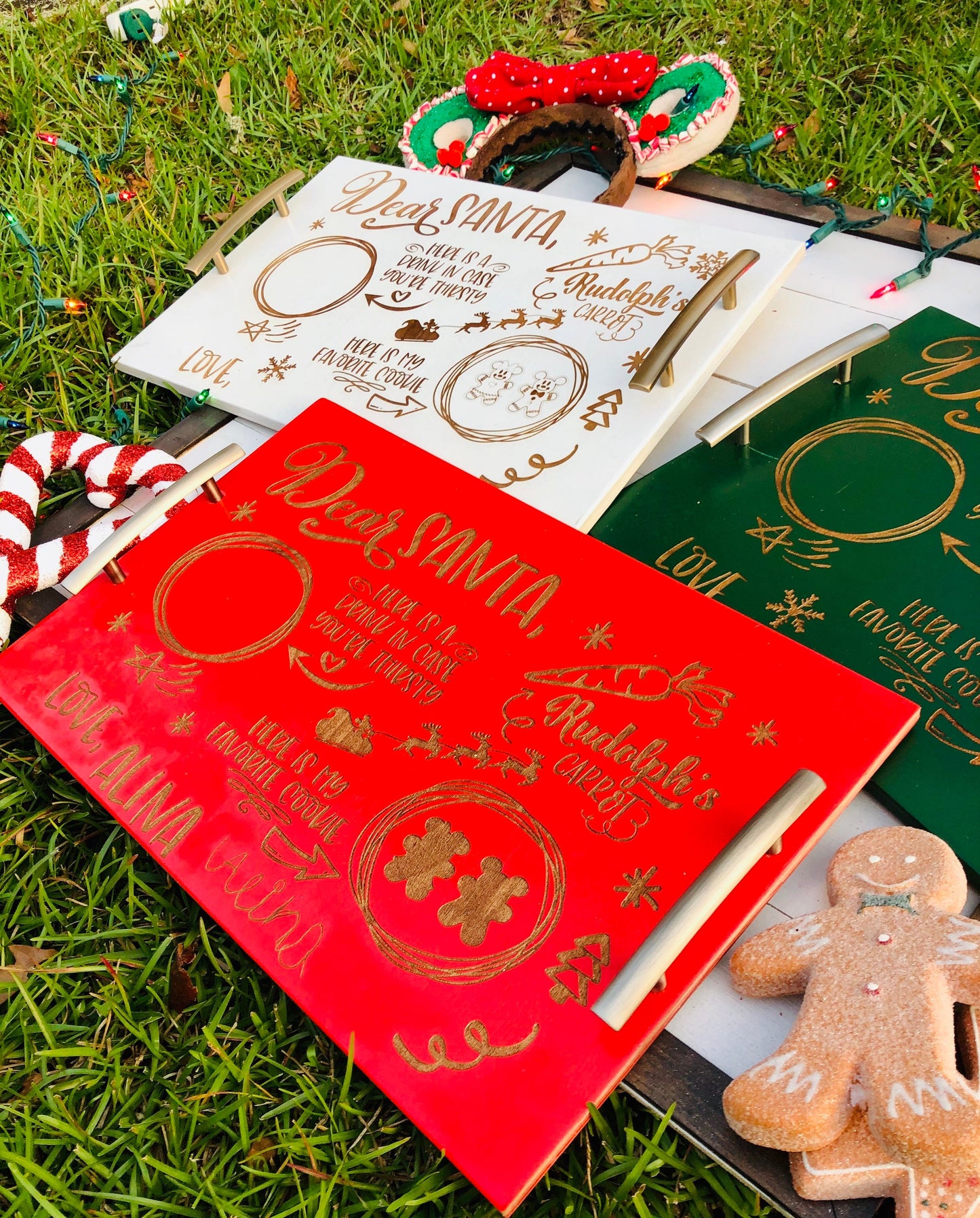 Set of personalized Christmas cards on grass with a gingerbread man cookie.
