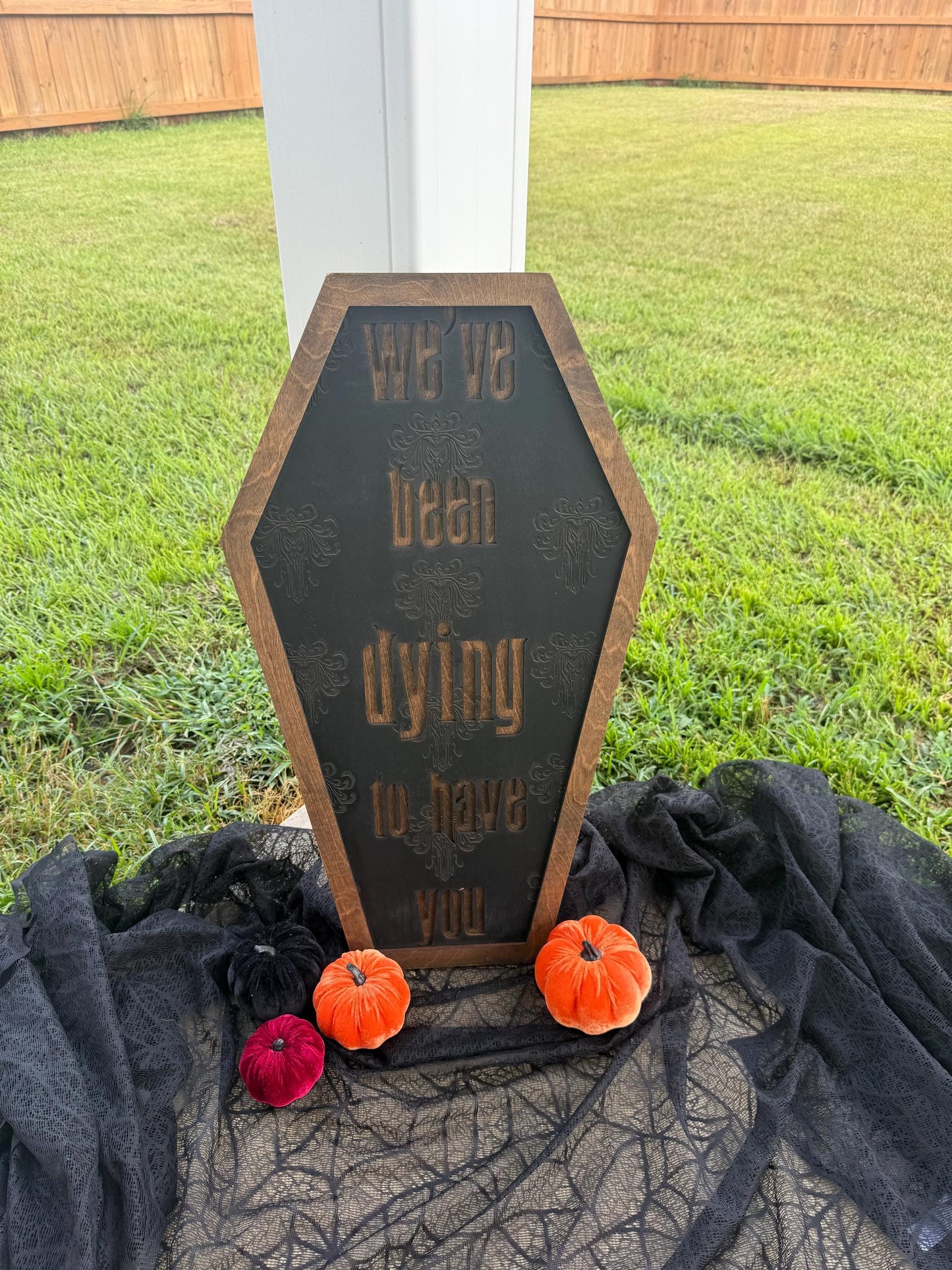 Decorative Halloween sign with pumpkins on a grassy background