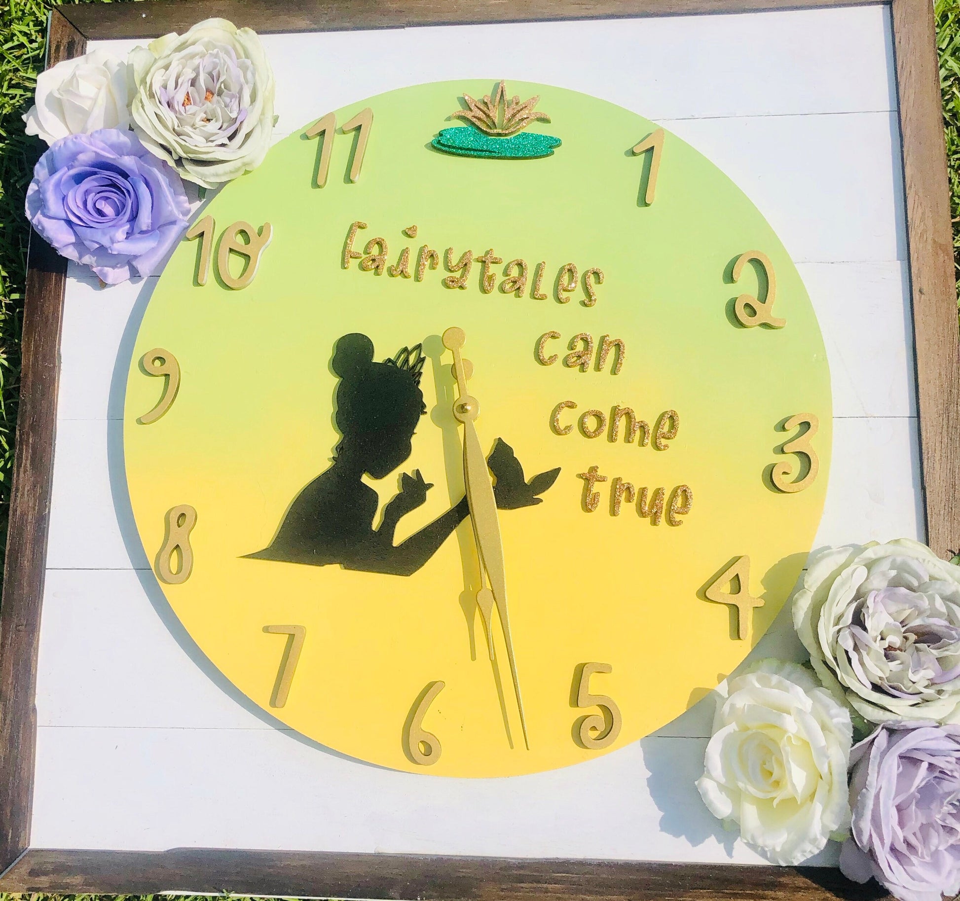 Decorative clock with fairy silhouette and 'fairytale can come true' text, surrounded by flowers.