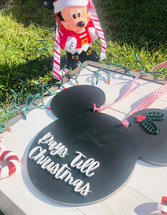 Decorative sign with 'Pray's Till Christmas' text, surrounded by festive decorations on grass.
