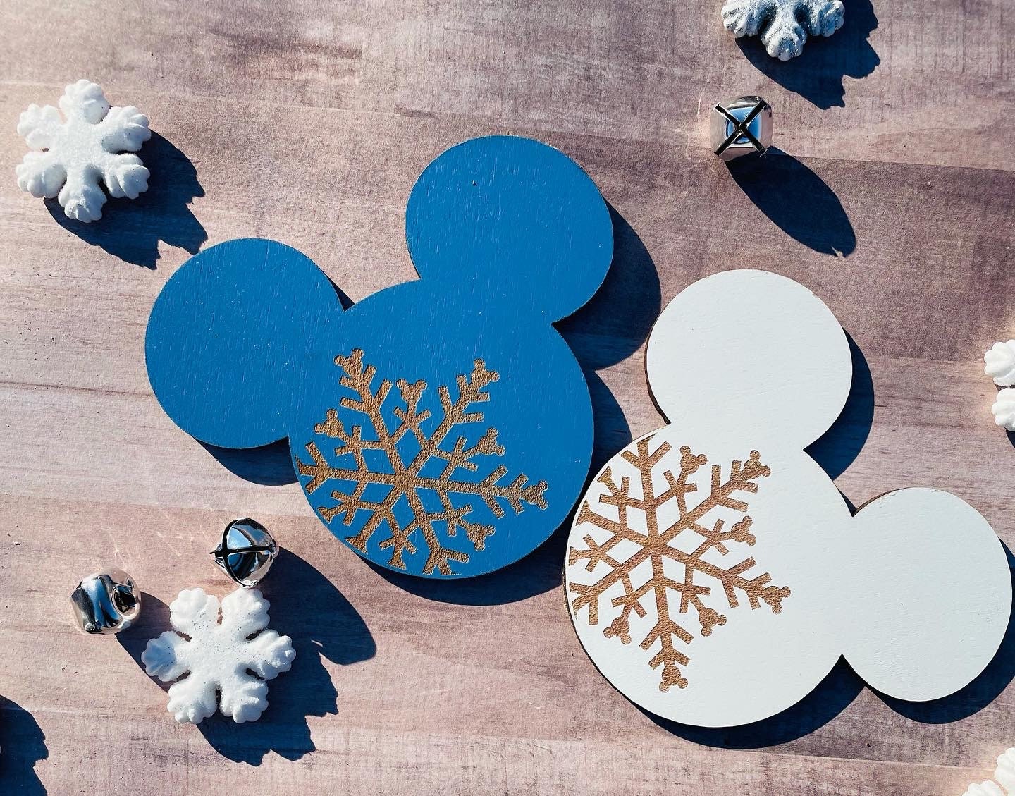 Blue and white mouse ears with gold snowflake designs on a wooden surface.