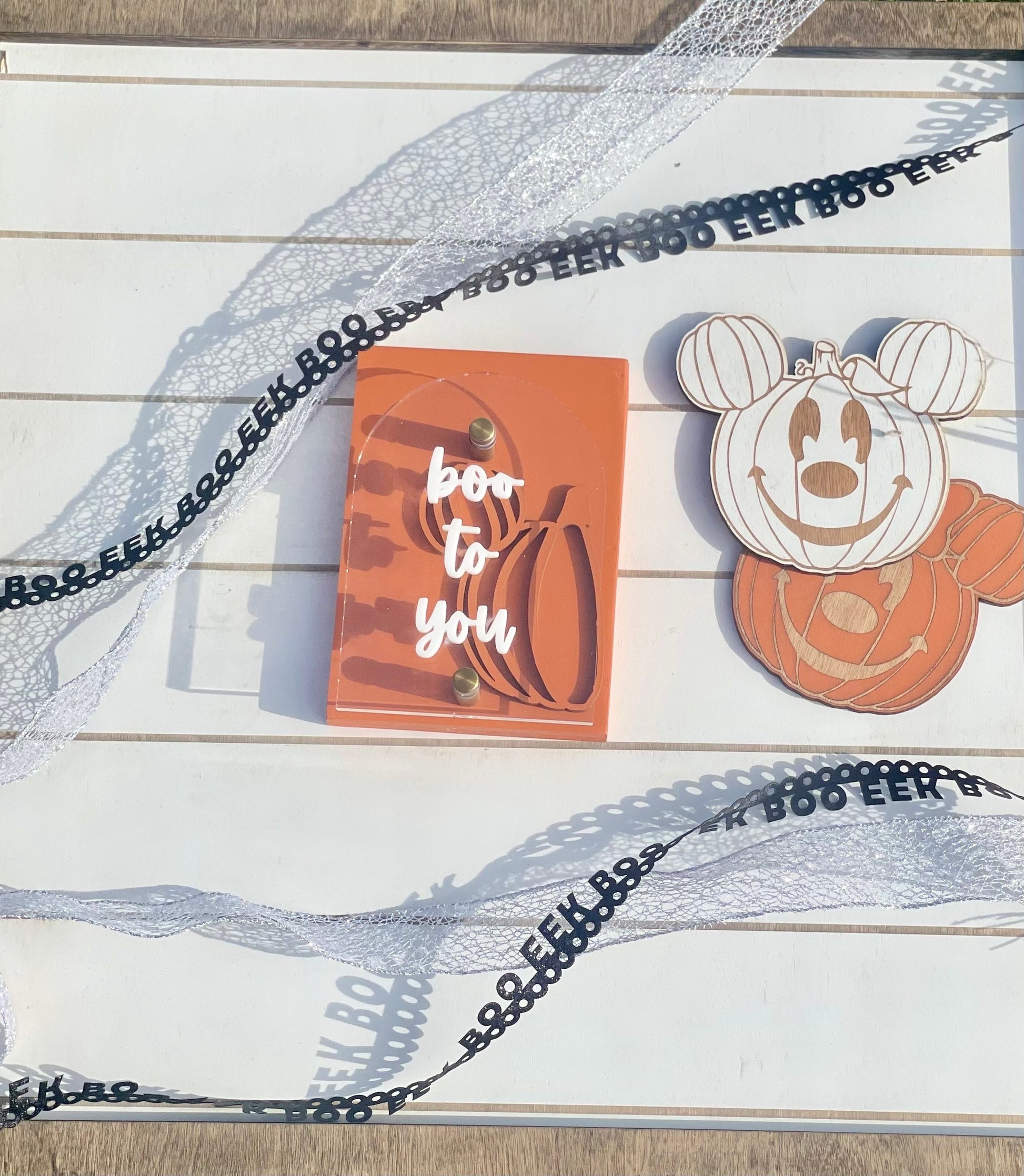 Halloween-themed card with a pumpkin design and 'boo to you' text on a wooden surface.