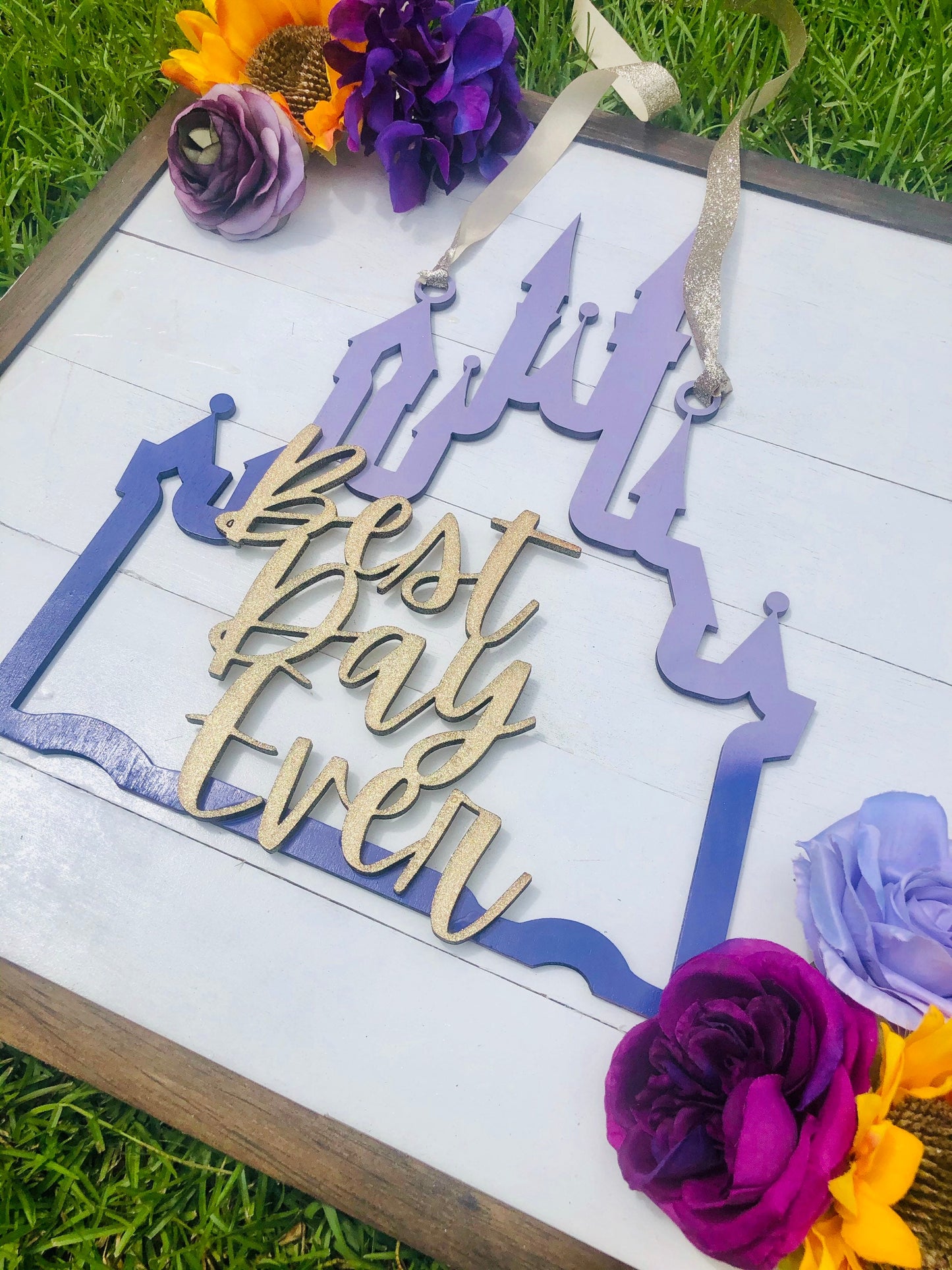 Decorative sign with 'Best Day Ever' text on a white background with flowers.