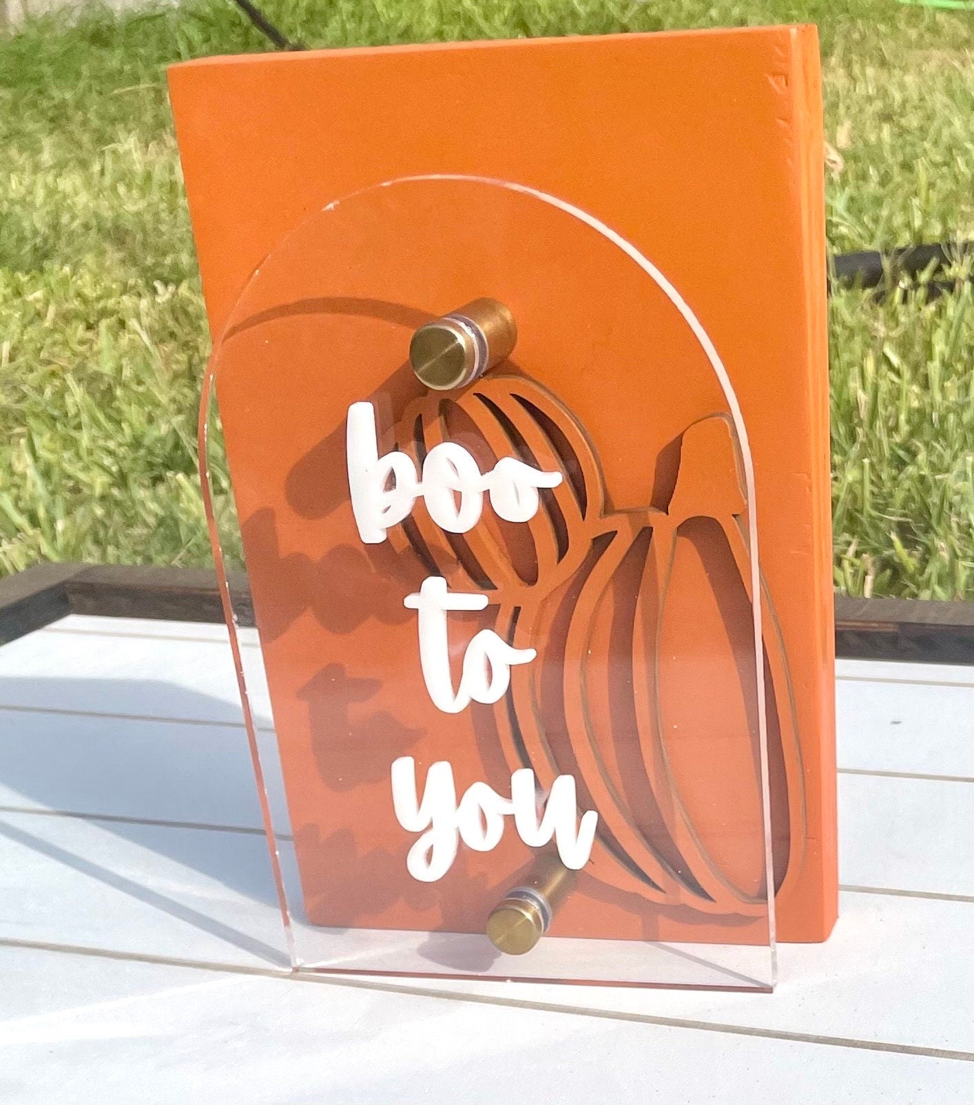 Orange card with 'boo to you' text and ghost design on a grassy background