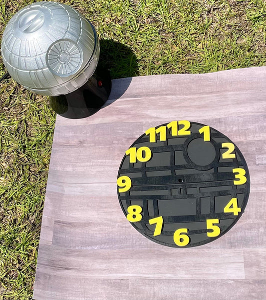 Dartboard shaped like a Death Star with numbers on a wooden board outdoors.
