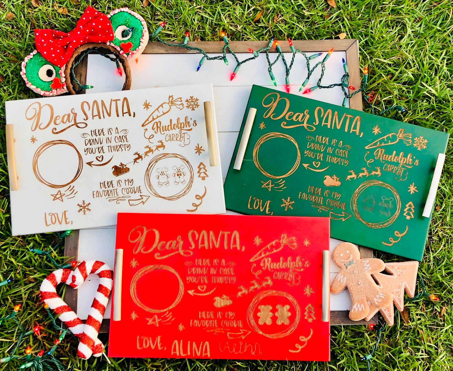 Three Christmas-themed letters addressed to Santa Claus on a grassy background with decorative items.