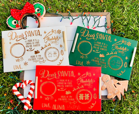 Three Christmas-themed letters addressed to Santa Claus on a grassy background with decorative items.