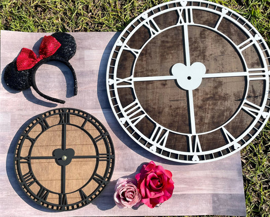 Decorative clock faces on a wooden surface with a Minnie Mouse headband and pink rose.
