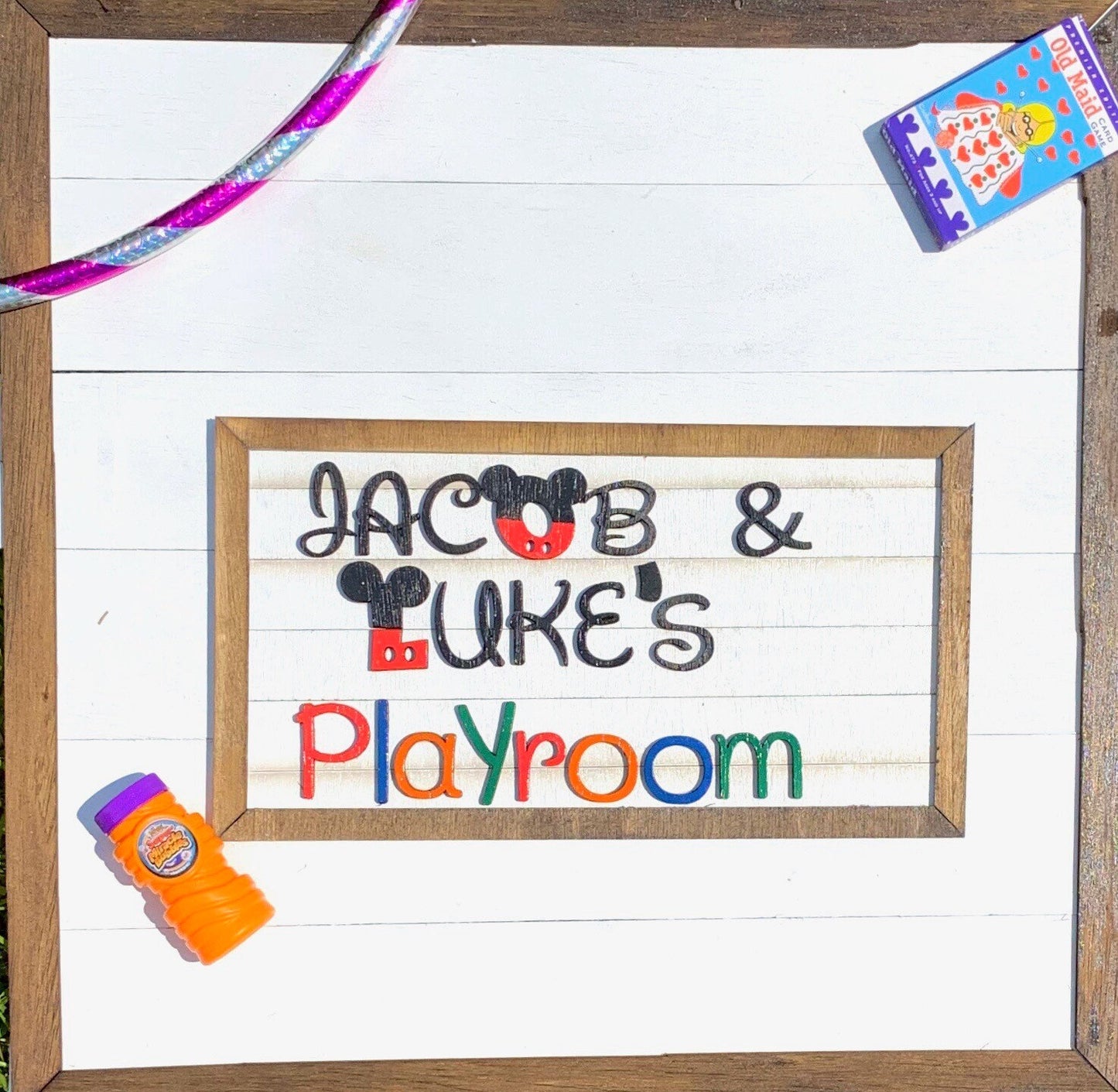 Wooden sign with 'Jacob & Luke's Playroom' text on a white background
