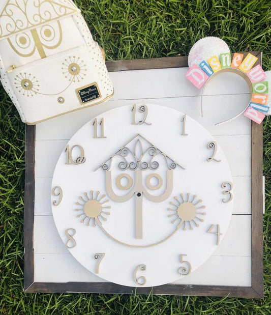 Decorative clock with ornate design on a wooden board, surrounded by grass.