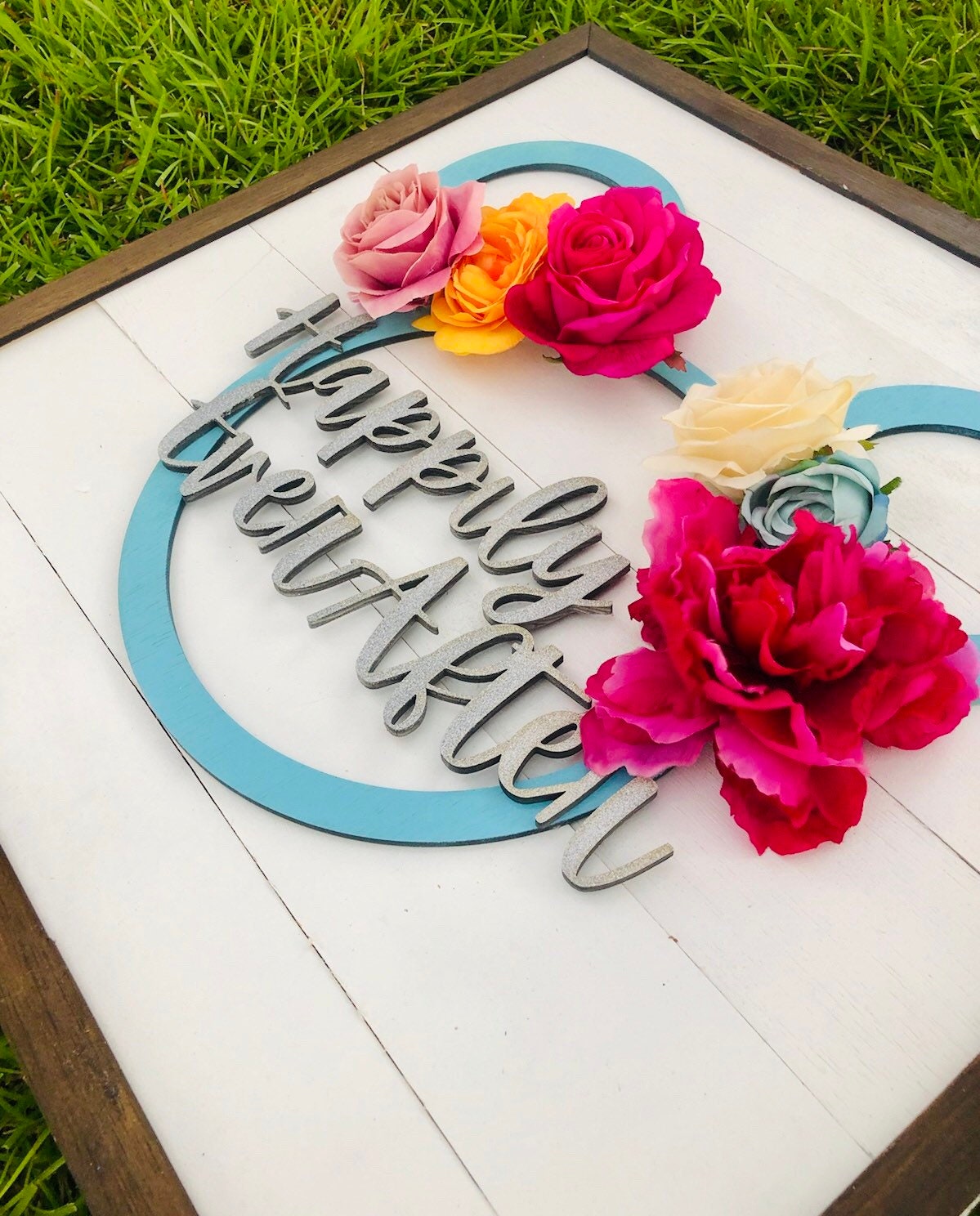 Decorative sign with flowers and 'Happy New Year' text on a grass background