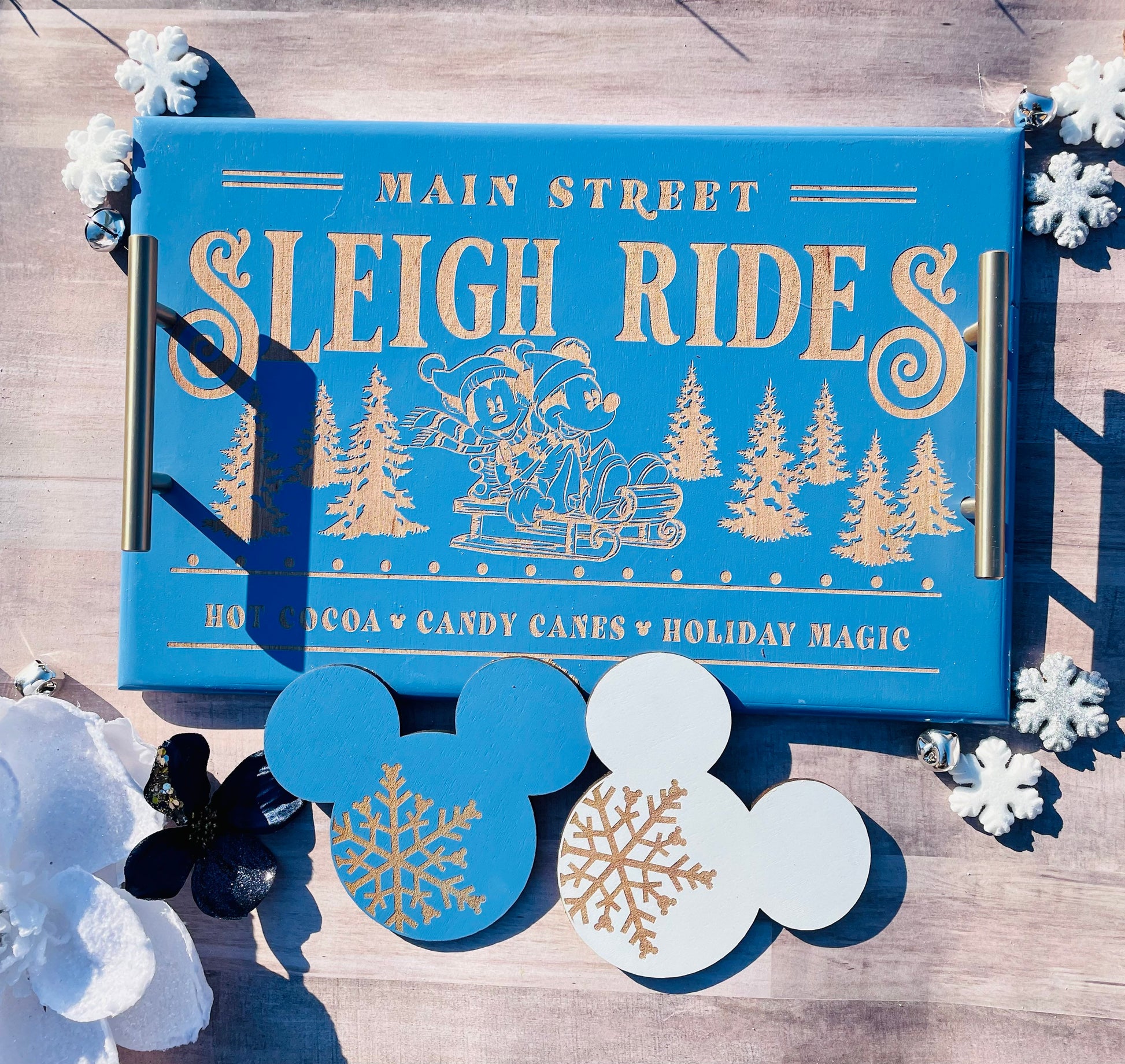 Blue box labeled 'Main Street Sleigh Rides' with holiday-themed design on a wooden surface.