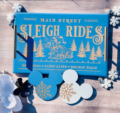 Blue box labeled 'Main Street Sleigh Rides' with holiday-themed design on a wooden surface.