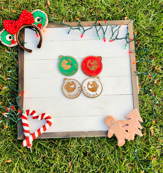 Set of Christmas-themed pins on a wooden board with decorative lights and ornaments on grass.
