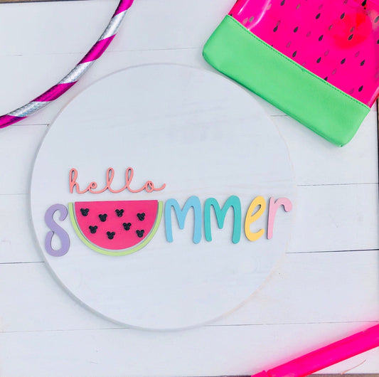 Decorative plate with 'hello summer' text and watermelon design on a white wooden surface.