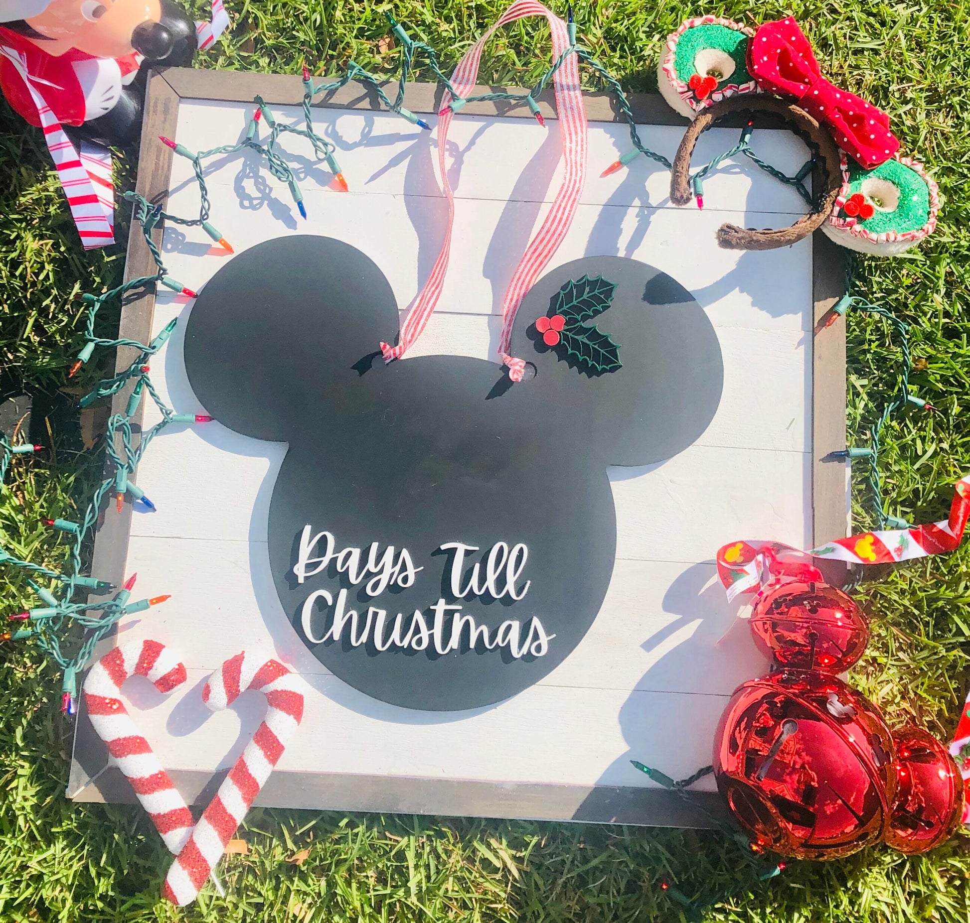 Christmas countdown sign with decorative elements on grass