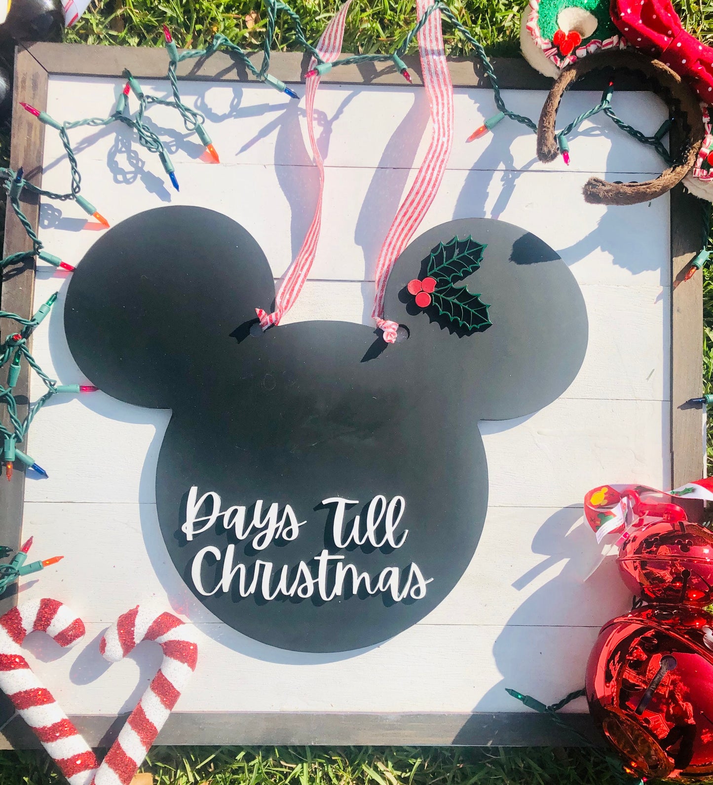 Decorative sign with Mickey Mouse ears and 'Days Till Christmas' text, surrounded by holiday decorations.