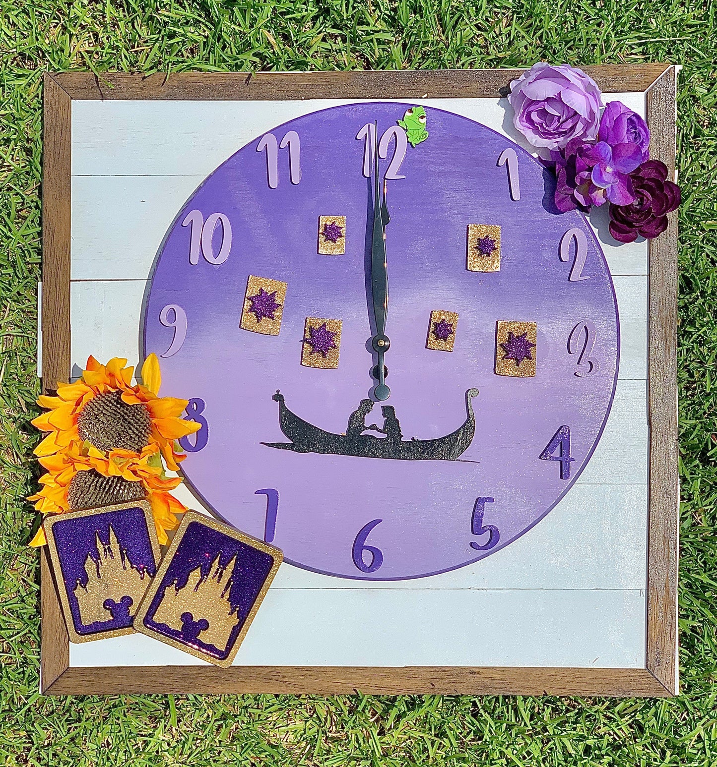 Decorative clock with purple face and wooden frame on grass