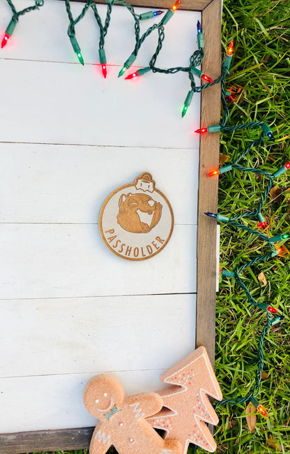 Wooden ornament with 'Passholder' branding on a white wooden board with Christmas lights.