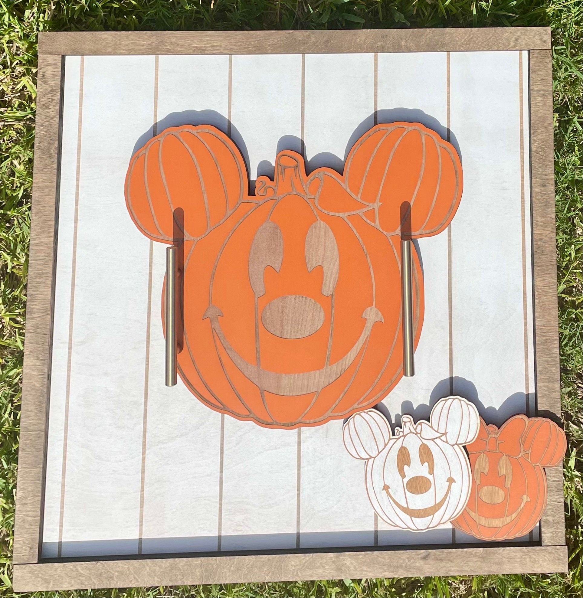 Decorative wall art with Mickey Mouse pumpkin design on a wooden frame.
